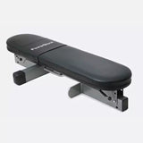 PowerBlock folding flat weight bench in black and silver, designed for compact home gyms and strength training in small spaces.