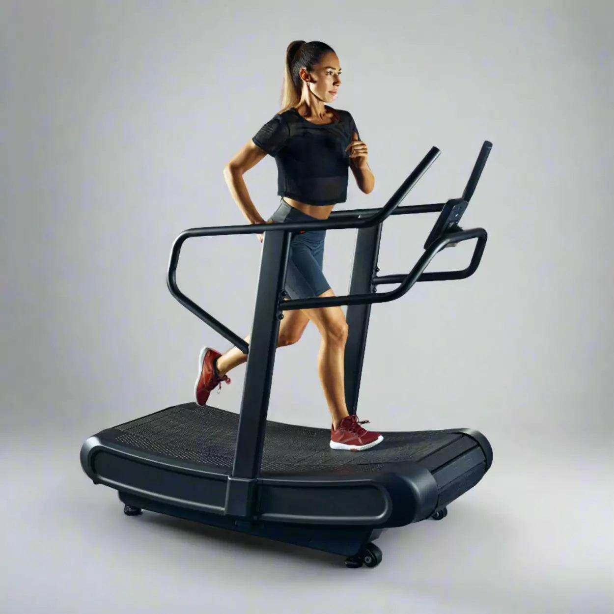 a woman running on a black curved tread mill