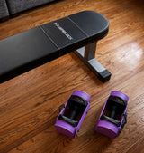 Nomad Powerblock weight bench on a wooden floor with purple/lavender sport 24 adjustable dumbbells