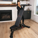 Woman standing at the PowerBench 2.0 with the dip attachment installed in a home gym