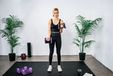 Woman exercising bicep curls with the sport 24 adjustable dumbbells lavender color in a home gym setting
